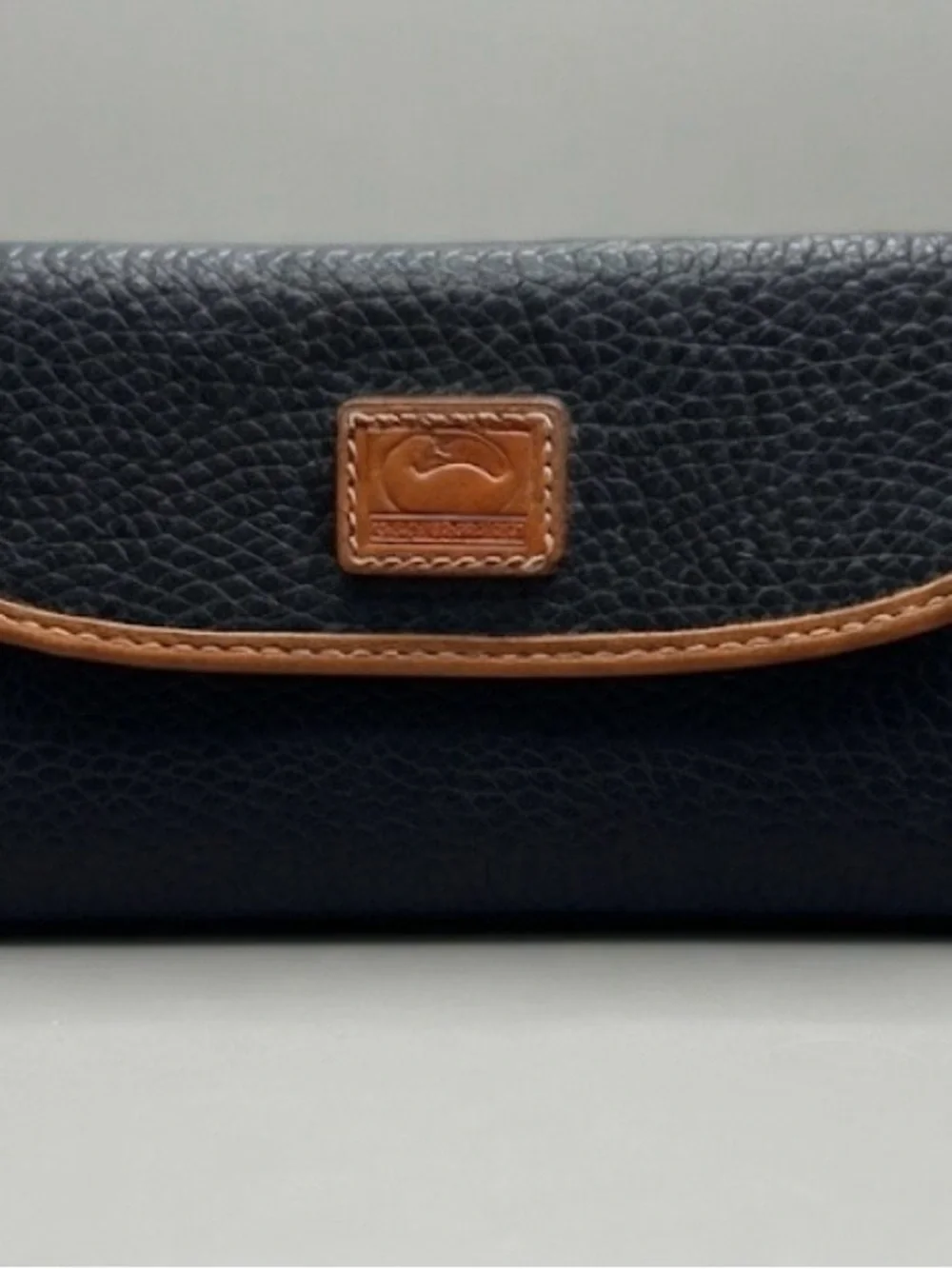 3 1/2”. X. 7”.  pebble-grain leather Dooney & Bourke Continental Clutch